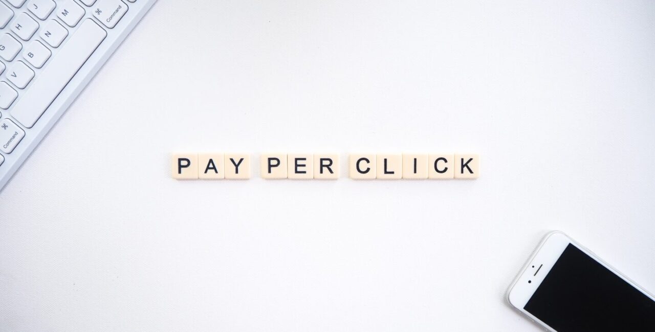 Pay per click or PPC on white background with Apple keyboard