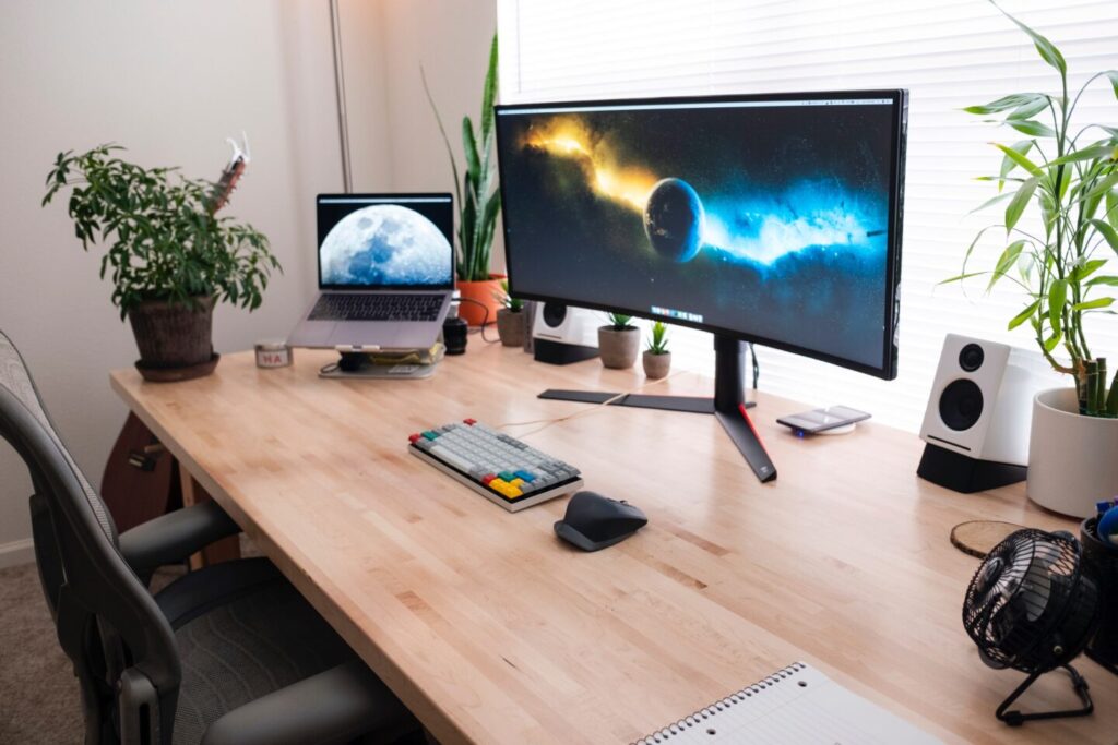 On the woood desk a laptop and a big monitor. Ice and fire in the monitore symbolize a competition Java vs Python