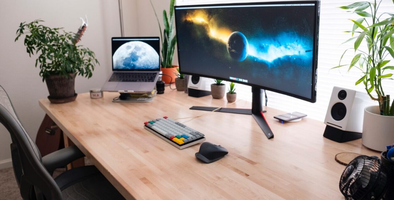 On the woood desk a laptop and a big monitor. Ice and fire in the monitore symbolize a competition Java vs Python