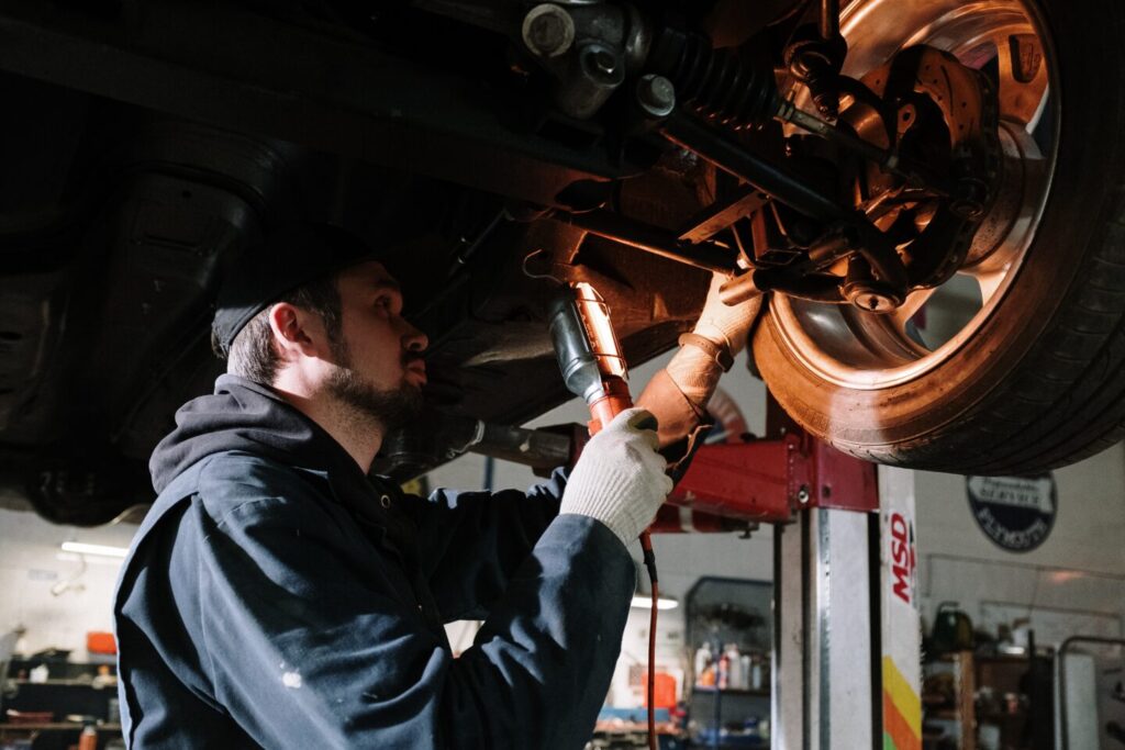 The auto mechanic is inspecting suspension of a car
