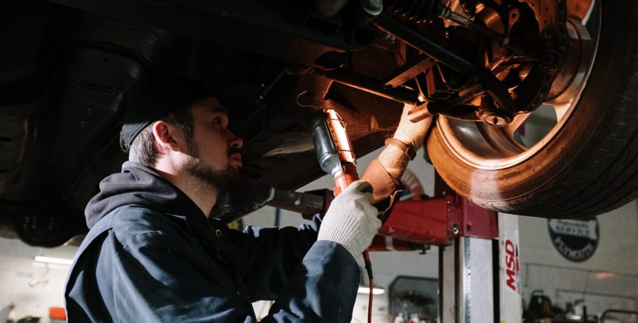 The auto mechanic is inspecting suspension of a car
