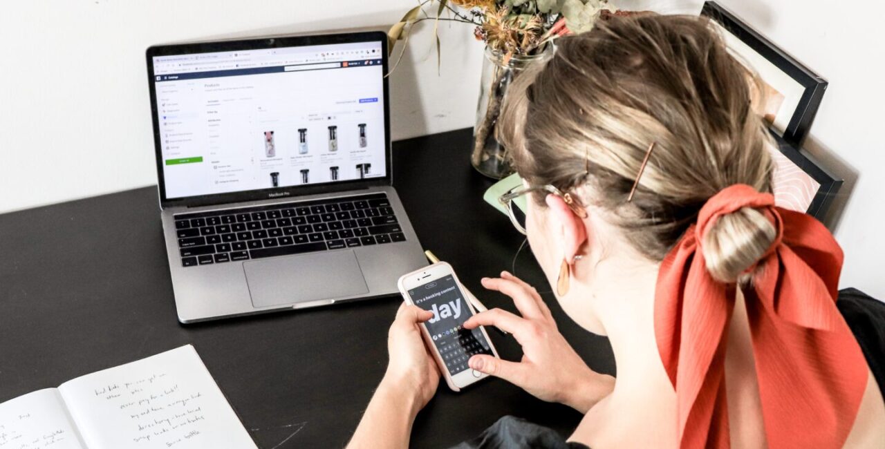 Women is using a smartphone and a laptop to compare mobile and desctop versions of ecommerce site that was built with Woocommerce