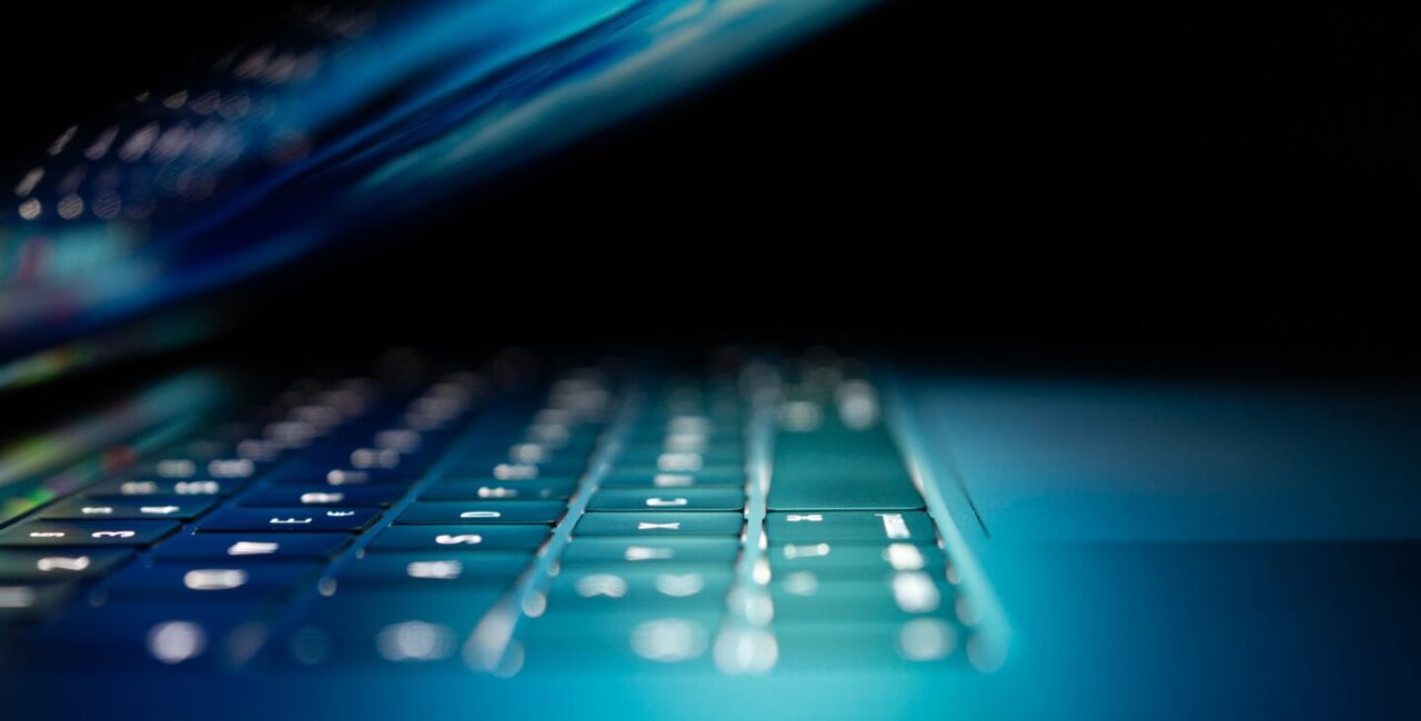 A laptop glows in the dark