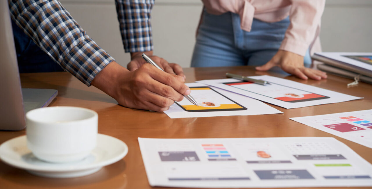 Hands of product manager making corrections on interface image