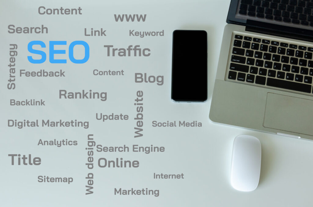 Top view laptop, smart phone and mouse are on the table. SEO and web text concepts on the table.