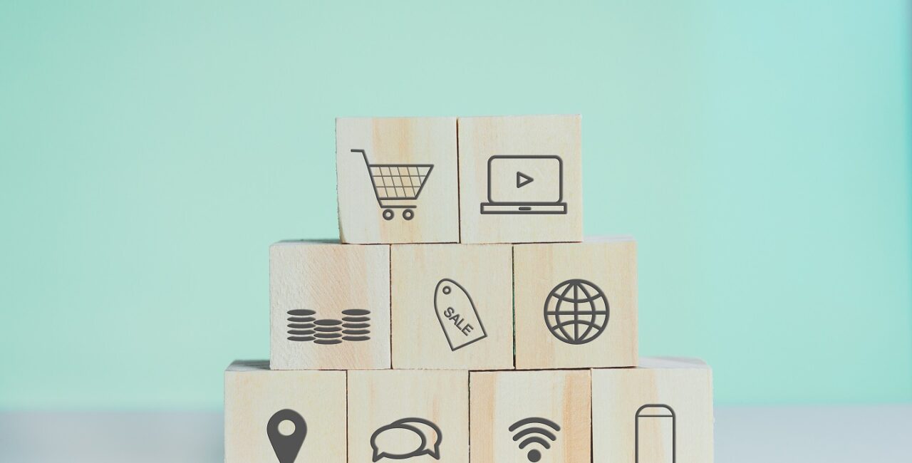 Wooden cubes with shopping online and marketing symbol on background and copy space.