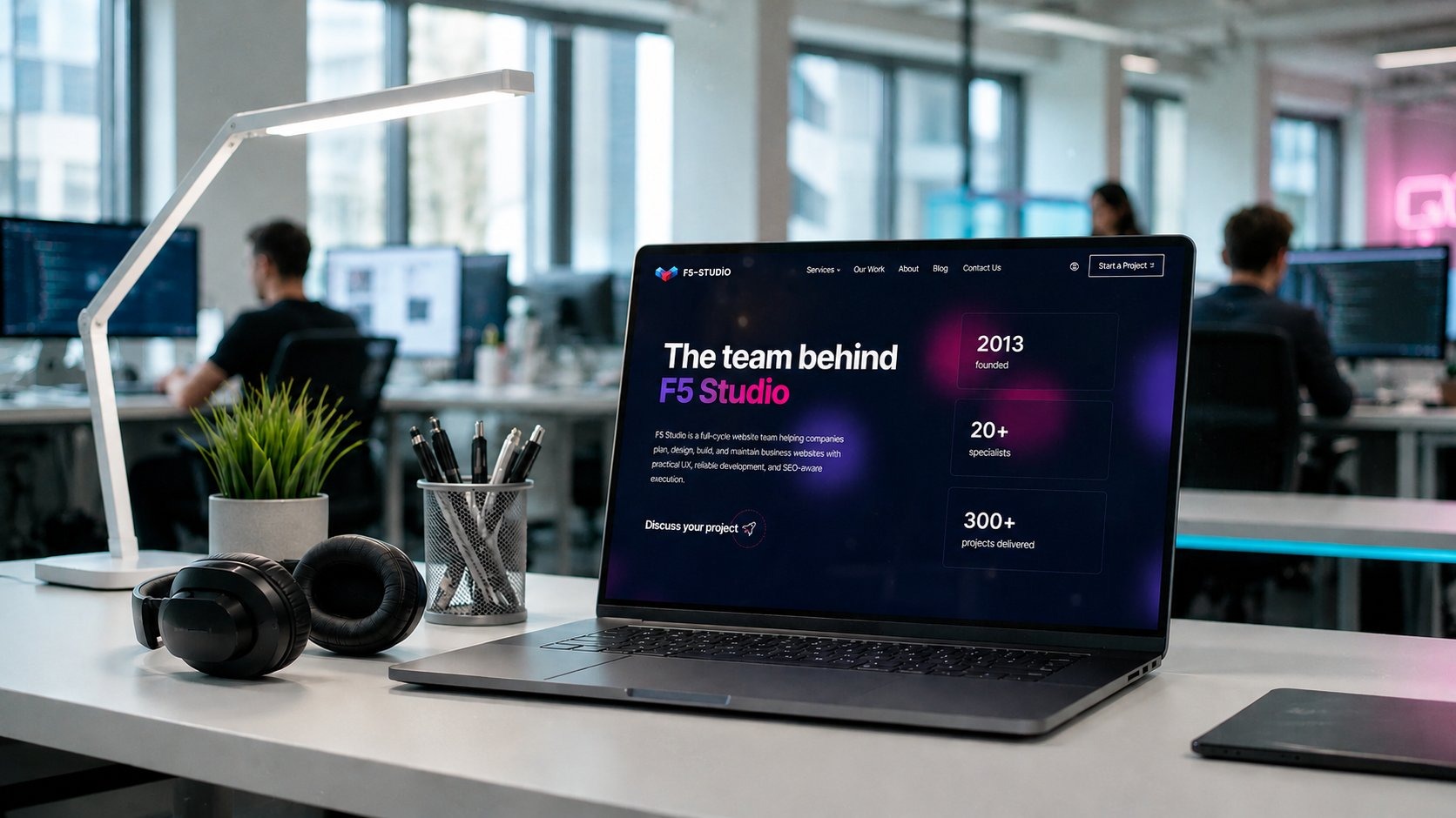 F5 Studio About-Seite auf einem Laptop am Entwickler-Arbeitsplatz in einem hellen modernen Büro