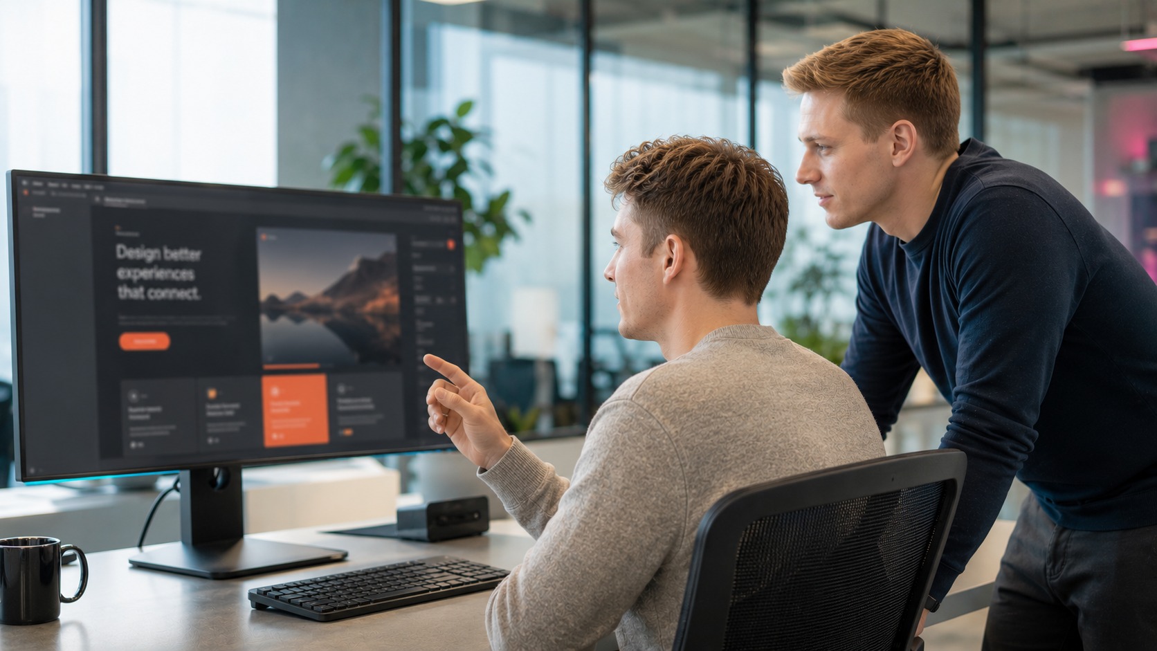 Zwei Spezialisten prüfen ein Front-End-Interface und Dashboard auf einem großen Monitor im Produktarbeitsplatz.